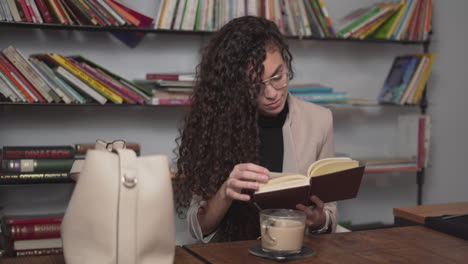 mujer leyendo un libro en un café