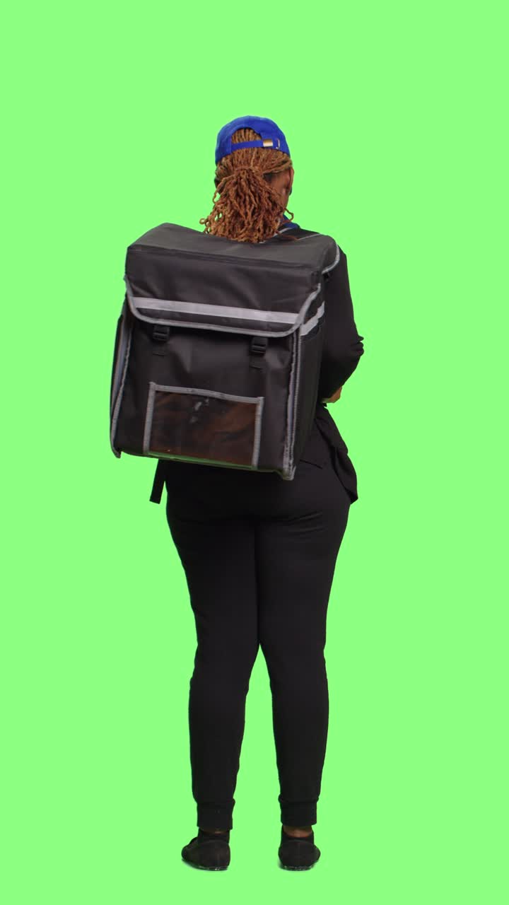 Vertical video: Courier delivering meal in thermal backpack and browsing internet