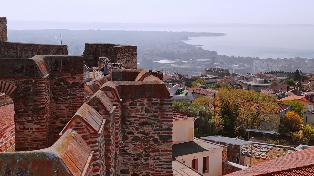 I visitatori esplorano le rovine mentre si godono la vista sul mare in Grecia.