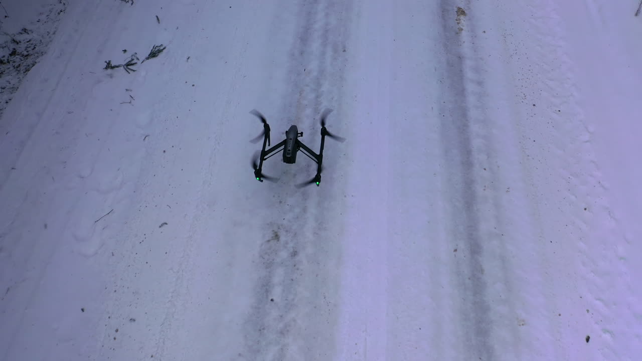 Drone flying at winter snowy forest. Drone with professional cinema camera flying over winter forest