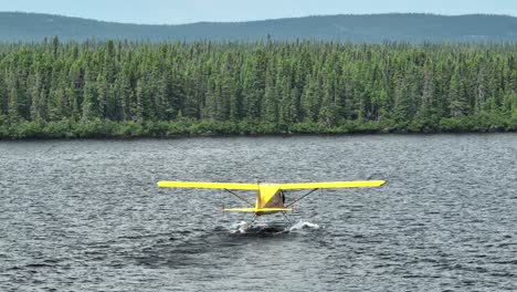 Captura-Con-Teleobjetivo-De-Un-Avión-De-Castor-Amarillo-Rodando-Para-Despegar-En-Un-Lago-Canadiense