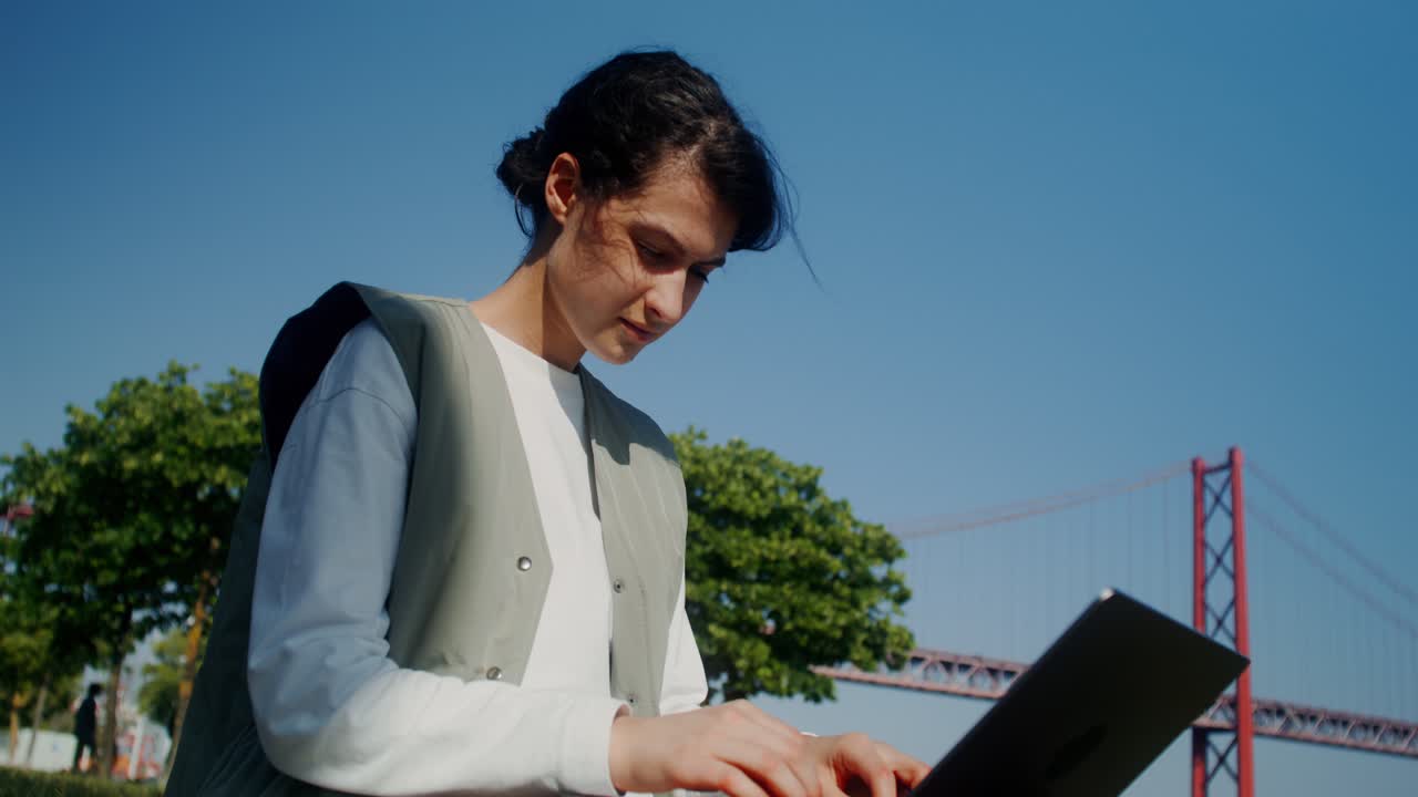 dom luís i 다리 근처의 공원에서 노트북에서 일하는 젊은 여성