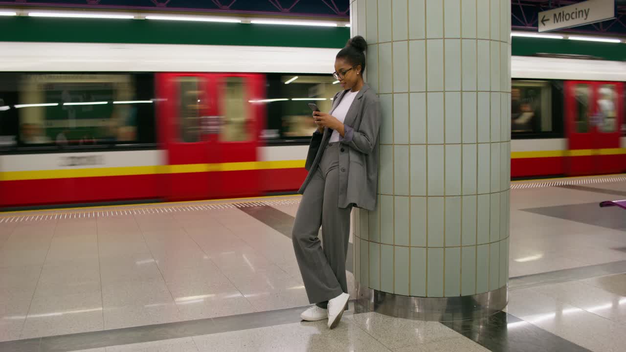 mujer usando el teléfono en una estación de metro