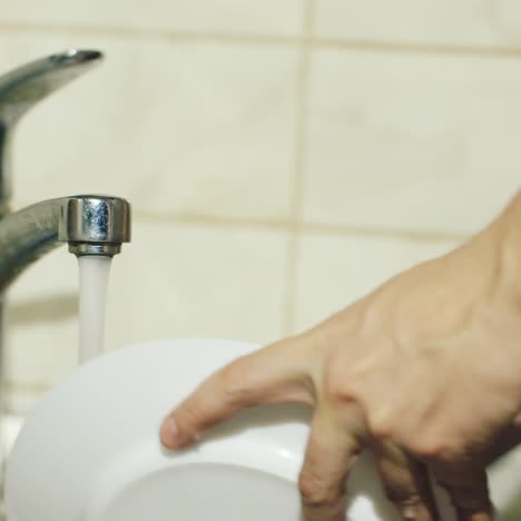 male hands washing dishes in the kitchen