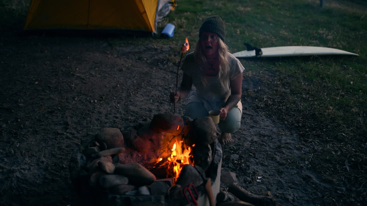 una joven atractiva asando malvaviscos por