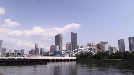 Sea-Level-view-of-Skyscrapers-of-Odaiba,-Tokyo-with-blue-sky-and-clouds