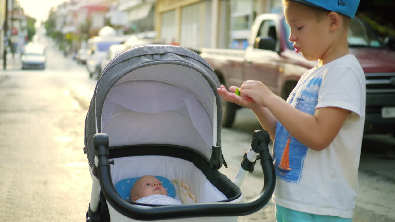 Boy with baby sister waiting for mom in the street