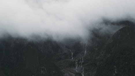 Cascadas-Que-Caen-En-Cascada-Por-Una-Montaña-Brumosa-Rodeada-De-Vegetación-Exuberante-Y-Acantilados-Rocosos