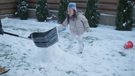 grandfather and granddaughter having fun in the snow