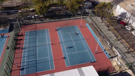 aerial shot showing tennis players at court playing doubles game outdoors in buenos aires