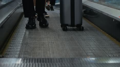 people and luggage on a moving walkway