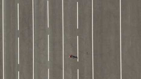 aerial view, a girl athlete trains on the square. girl on roller skates goes around the cones. view from the copter. 4k, 10bit, prores