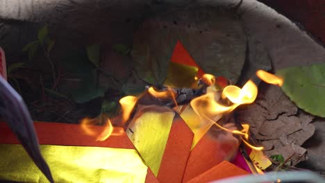 sequential burning of colorful paper in a ritual