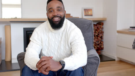 Portrait-of-happy-african-american-man-in-bright-living-room,-slow-motion