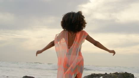 beautiful mixed-race woman playing with her hair on the beach