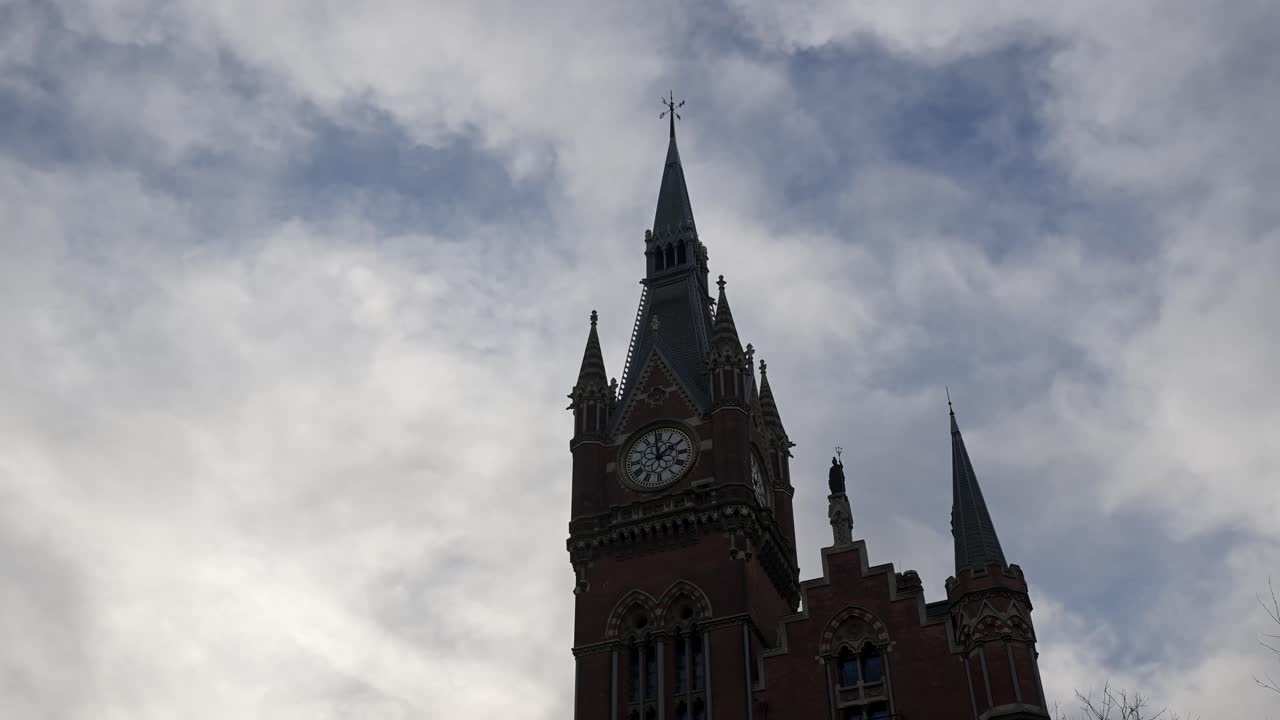 The magnificent High Victorian Gothic facade and clock tower of the St Pancras London hotel illuminated at dusk near Kings Cross station in the Camden district
