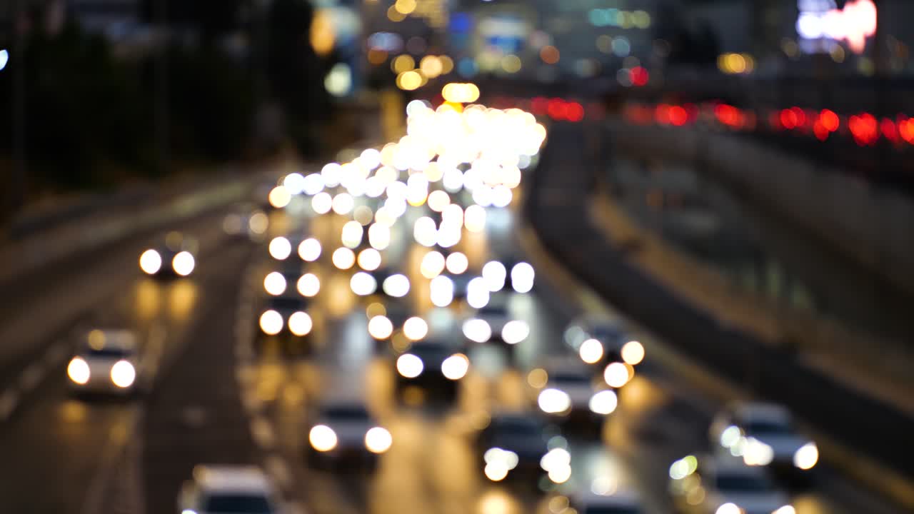 Tett rushtrafikk med billys i mørket, uskarpt bilde