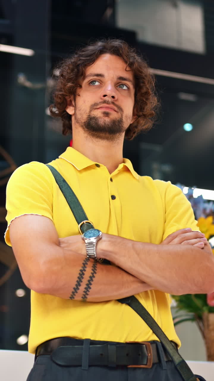 Man in yellow shirt standing in an office building. Vertical