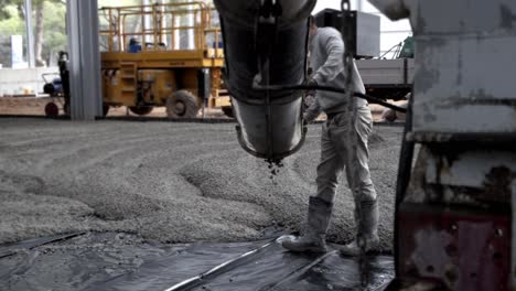 workers apply a layer of cement to create the floor of a large area under construction