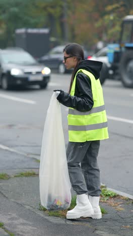 mujer limpiando la basura en la calle