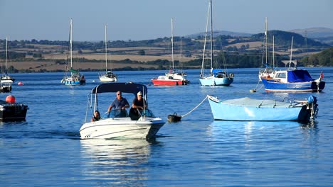 a small motorised boat traveling along the river tamar in saltash between devon and cornwall on a summers day