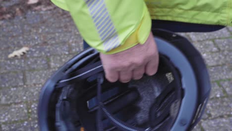 male cyclist holds bike helmet in his hands