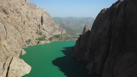 epic cinematic drone shot inside the ravine surrounding the kel-suu lake in kyrgyzstan