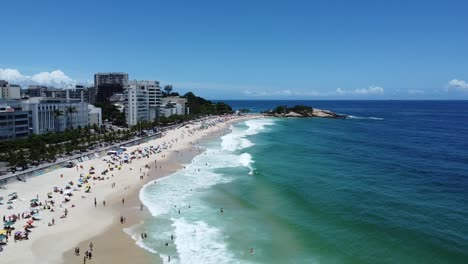 traveling-forward-with-drone-towards-Arpoador-beach-in-Rio-de-Janeiro,-Ipanema-beach-on-a-sunny-day-and-blue-sky