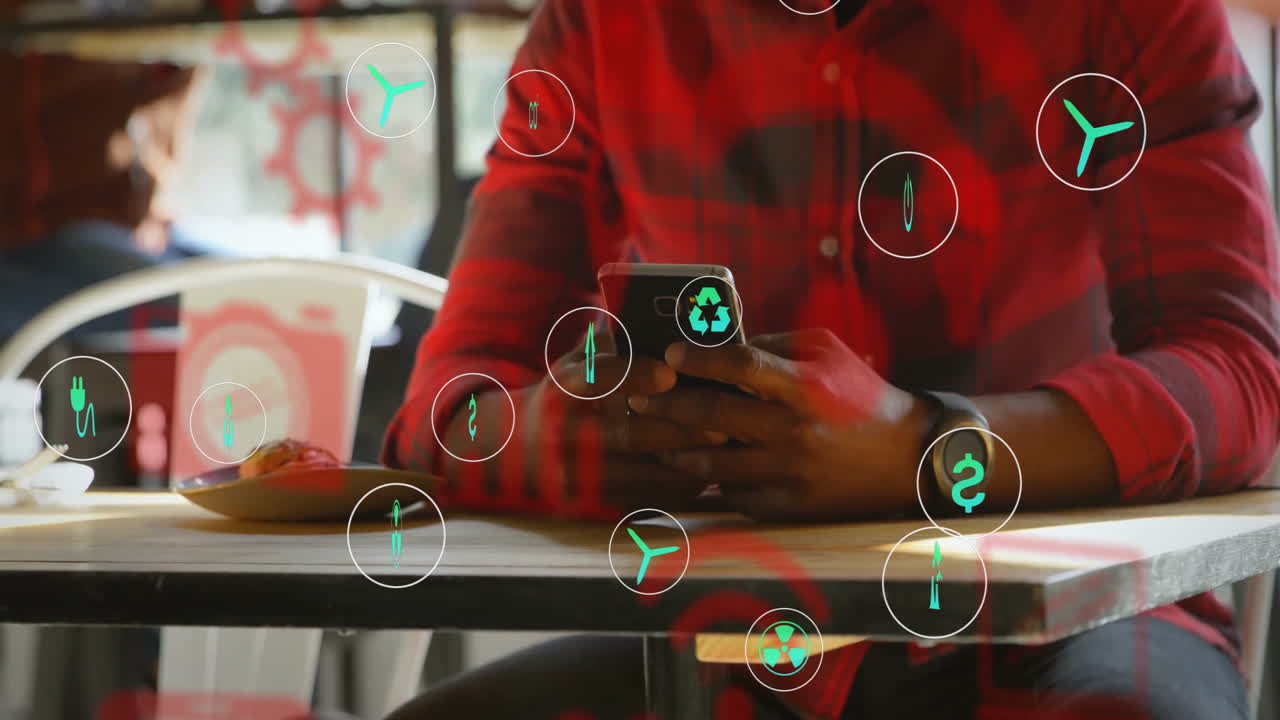 Using smartphone, person in cafe with animation of eco-friendly icons overlay