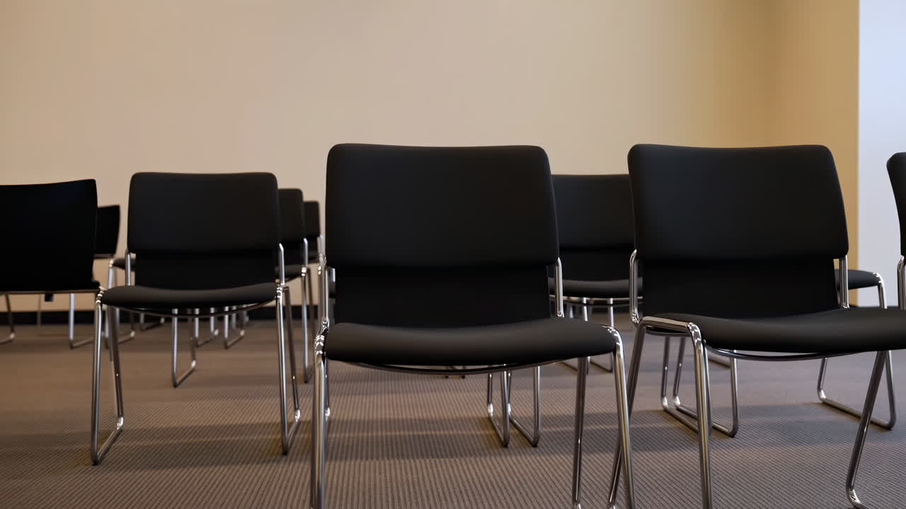 Empty Black Chairs Arranged in a Conference Room
