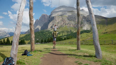 hikers enjoy giant swing at williamshüttein in scenic landscape of seiser alm, italy