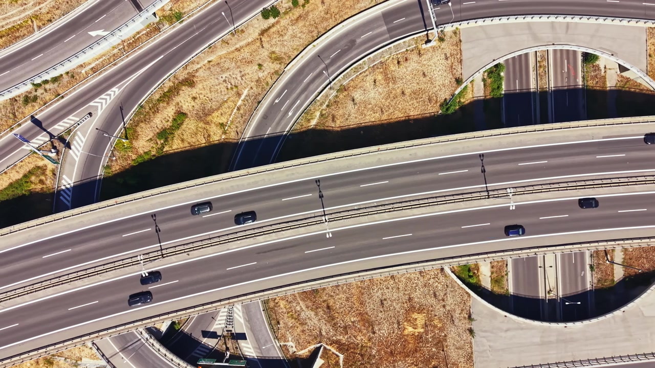 Highway interchange showing multiple levels of roads during daytime with vehicles traveling