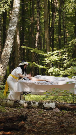 therapist female doctor making woman relaxing spa face massage with hands outdoors in the forest