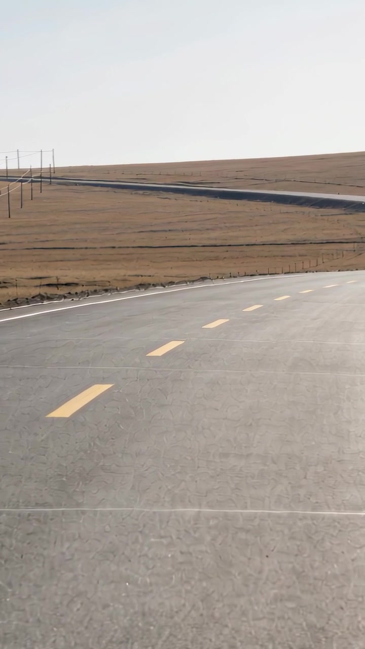 Video verticale: Telecamera che avanza su un'autostrada asfaltata, mostrando segnaletica orizzontale gialla tratteggiata fino all'orizzonte.