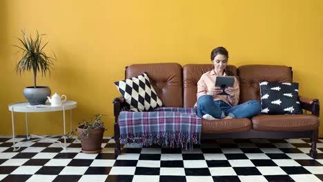 woman relaxing on a couch with a tablet