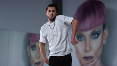 bailarín de ropa deportiva moviendo las manos en el gimnasio. hombre guapo bailando para la cámara en clase.