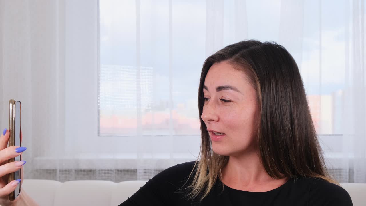 블로거 소녀는 무선 인터넷을 사용하여 스마트폰에서 소셜 네트워크에서 친구들과 비디오 통신을 통해 이야기합니다.