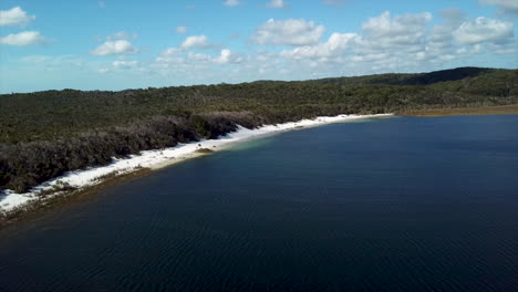 drone disparó al lago mckenzie en la isla fraser australia descendiendo hacia la playa de arena blanca