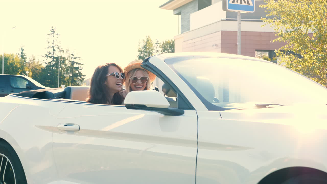 dos mujeres disfrutando de un viaje de verano en un descapotable