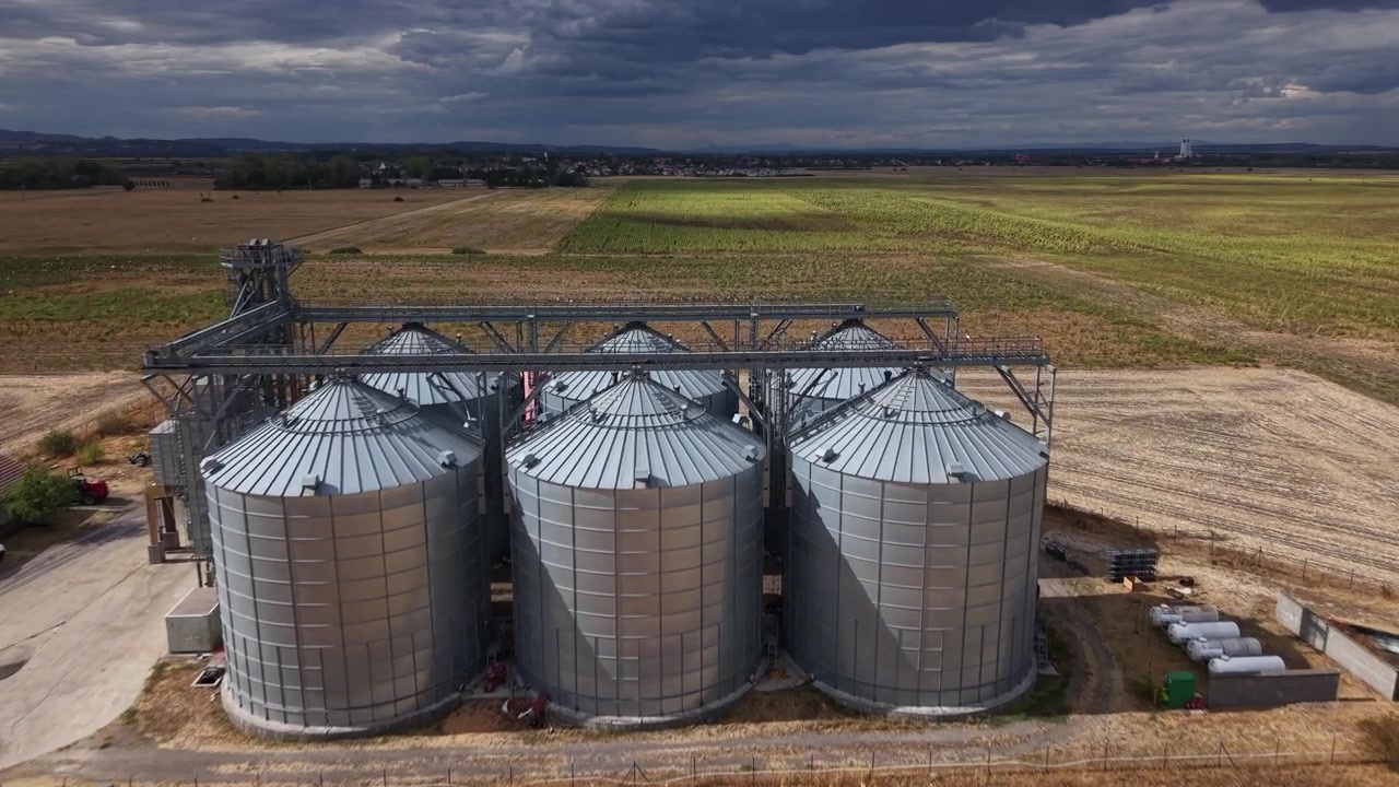 An aerial view captures expansive grain storage silos within a vast agricultural landscape, crucial for food supply and harvest.