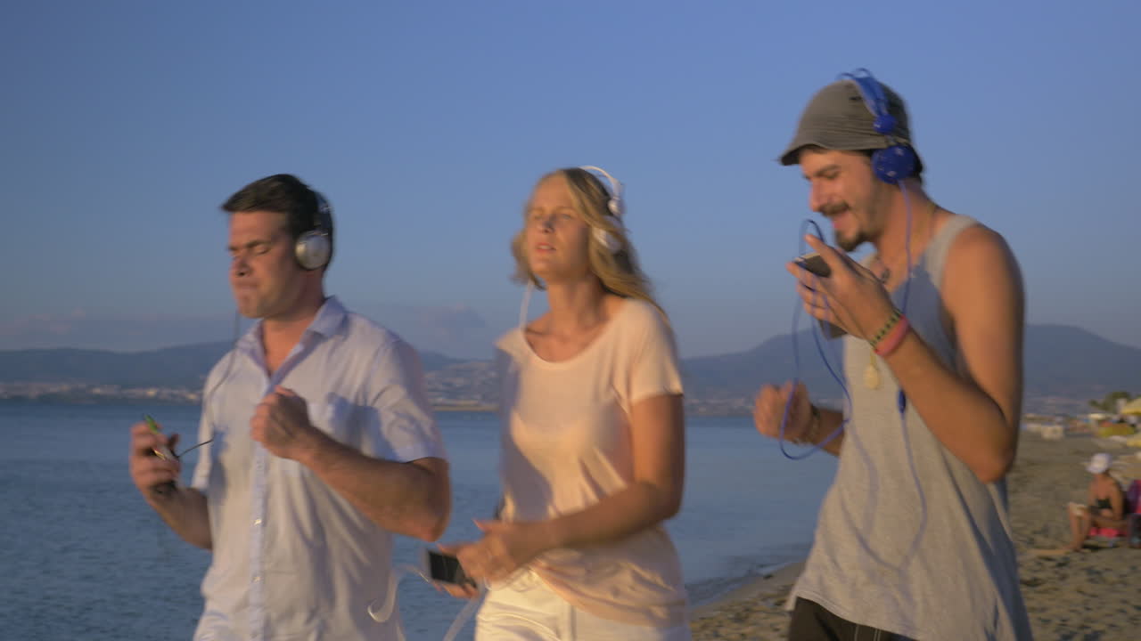 해변에서 음악과 함께 춤추는 행복한 친구들