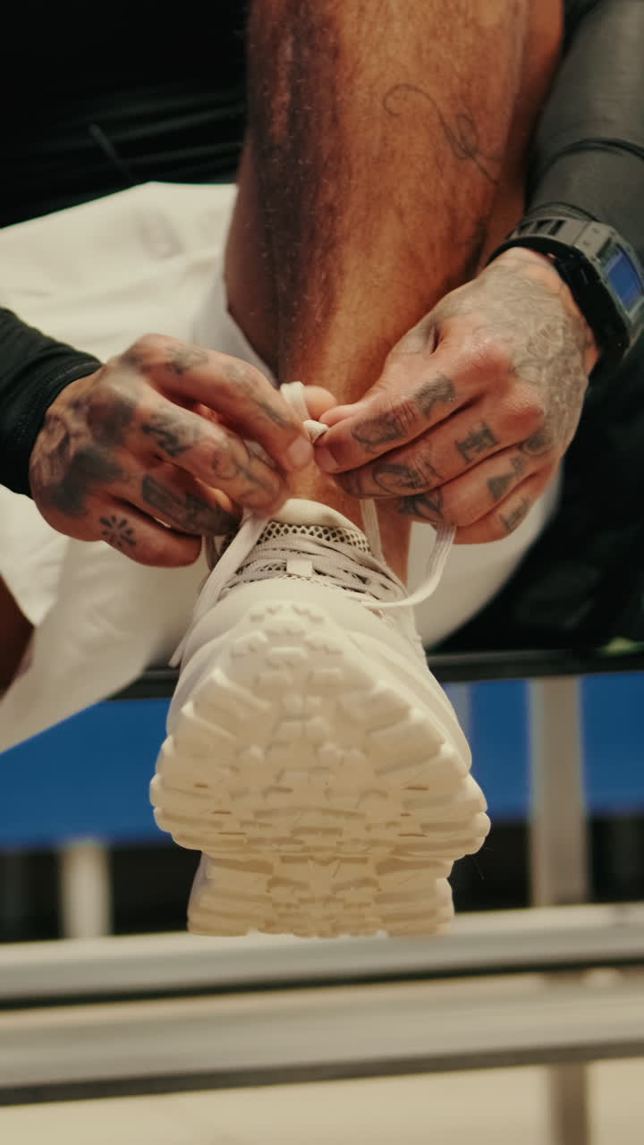 Close-up of Person Tying Shoelaces on White Athletic Sneaker