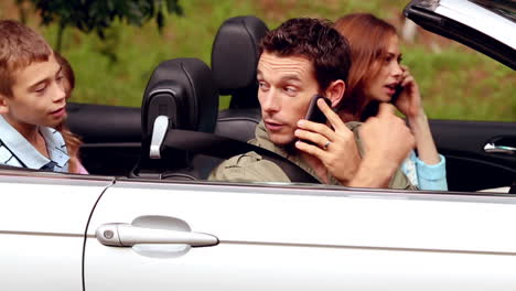 Parents-on-the-phone-in-a-convertible-car