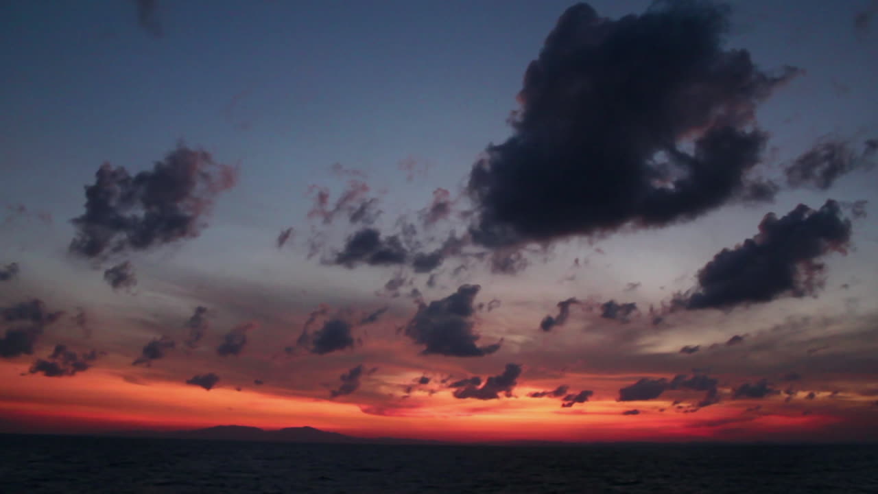 Dramatic and cinematic colors fill the sky over the Andaman Sea at sunrise