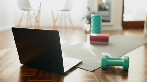 Dumbbells,-floor-and-laptop-in-living-room