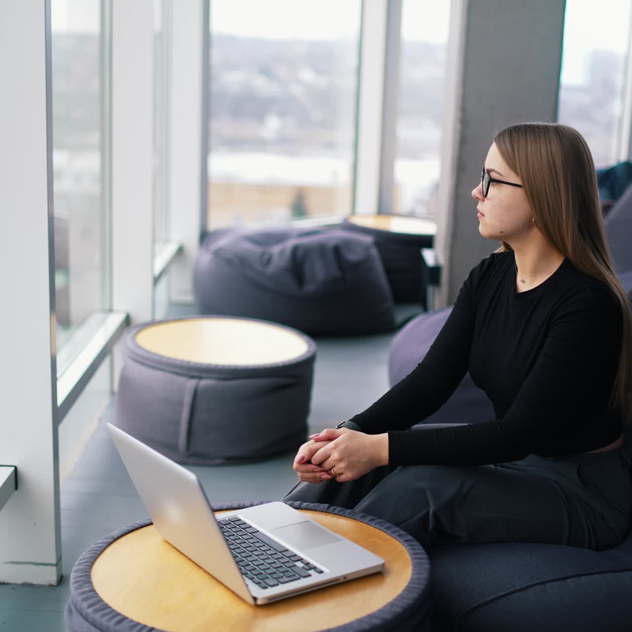 young woman wearing eyeglasses working on laptop computer