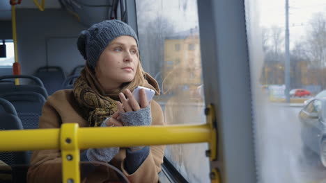 woman with smartphone riding a bus