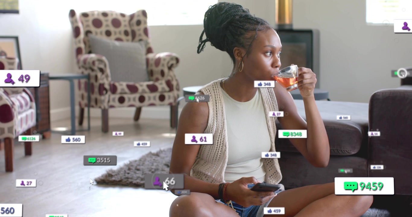 Creator sipping tea in room and starting social media engagement metrics while reading messages