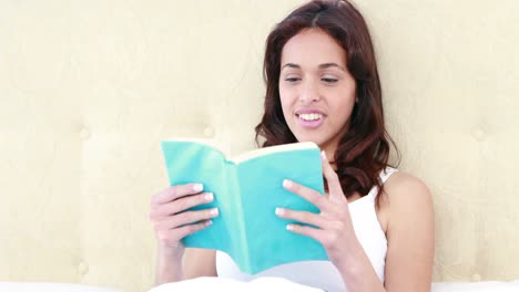 Pretty-woman-reading-a-book-in-her-bed-