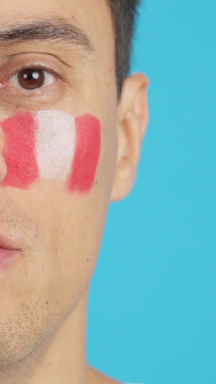 Man with a peruvian flag painted on the face smiling